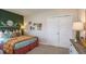 Bright bedroom featuring green accent wall, decorative shelves, and closet with white sliding doors at 7384 Capstone Dr, Groveland, FL 34736