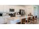 Modern kitchen featuring stainless steel appliances, shaker cabinets, and an island with barstool seating at 7384 Capstone Dr, Groveland, FL 34736