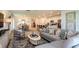 Open-concept living room flows to dining and kitchen, showcasing a neutral palette and modern furnishings at 7384 Capstone Dr, Groveland, FL 34736