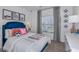 A modern bedroom with a blue headboard, soccer themed decorations, and bright natural light at 7392 Capstone Dr, Groveland, FL 34736