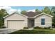 Charming single-story home with a two-car garage, lush lawn, and attractive neutral-toned facade at 7392 Capstone Dr, Groveland, FL 34736