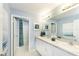 Modern bathroom featuring double sinks, white cabinets, and a framed mirror at 7404 Capstone Dr, Groveland, FL 34736