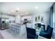 Modern kitchen features white cabinets, stainless steel appliances, island with seating, and adjacent dining area at 7404 Capstone Dr, Groveland, FL 34736