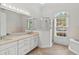 This bathroom features double sinks, a bathtub, a stand-up shower, and a window at 839 High Pointe Cir, Minneola, FL 34715