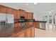 A kitchen displays wooden cabinetry, stainless steel appliances, and granite countertops at 839 High Pointe Cir, Minneola, FL 34715