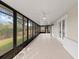 Large sunroom with a ceiling fan and views of the lush green backyard at 839 High Pointe Cir, Minneola, FL 34715