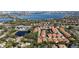 Wide aerial view of neighborhood featuring manicured lawns, clay tile roofs, tennis courts, and lakes at 8950 Della Scala Cir, Orlando, FL 32836