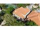 Aerial view of the back of a home with a screened-in porch, patio, and access to a tennis court at 8950 Della Scala Cir, Orlando, FL 32836