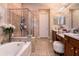 Elegant bathroom featuring a soaking tub, glass shower, and vanity at 8950 Della Scala Cir, Orlando, FL 32836