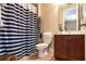 Bathroom with a blue striped shower curtain and warm neutral walls at 8950 Della Scala Cir, Orlando, FL 32836