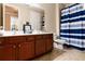Bright bathroom featuring a double vanity with dark wood cabinets and a blue-striped shower curtain at 8950 Della Scala Cir, Orlando, FL 32836