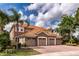 Beautiful home featuring a clay tile roof, stone accents, and a spacious three-car garage at 8950 Della Scala Cir, Orlando, FL 32836