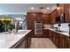 Modern kitchen featuring dark wood cabinetry, stainless steel appliances, and a marble countertop at 8950 Della Scala Cir, Orlando, FL 32836