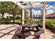 Charming picnic area with a table, benches, and a pergola, offering scenic views of the community's pond at 8950 Della Scala Cir, Orlando, FL 32836