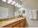 Bathroom with double vanity, granite countertops, well-lit mirror, and decorative towels at 8962 Sugar Palm Rd, Kissimmee, FL 34747