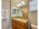 Well-lit bathroom featuring granite countertop vanity and a glimpse of the tiled shower at 8962 Sugar Palm Rd, Kissimmee, FL 34747
