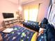 Comfortable bedroom featuring two twin beds, a TV, and playful decor for a -friendly space at 8962 Sugar Palm Rd, Kissimmee, FL 34747