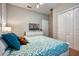 Bright bedroom with a blue and white patterned bedspread, white dresser, and ample closet space at 8962 Sugar Palm Rd, Kissimmee, FL 34747