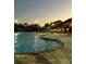 Inviting community pool featuring water fountains, lounge seating, and palm trees under a twilight sky at 8962 Sugar Palm Rd, Kissimmee, FL 34747