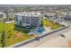 Aerial view of the building with a pool, lawn, and beach access at 901 S Atlantic Ave # 208, Ormond Beach, FL 32176