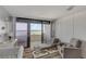 Cozy bedroom with a crib, seating, and sliding glass doors leading to a balcony with ocean views at 901 S Atlantic Ave # 208, Ormond Beach, FL 32176