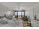 Bright bedroom featuring a crib, seating area, and access to a balcony with ocean views at 901 S Atlantic Ave # 208, Ormond Beach, FL 32176