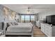 Serene primary bedroom with ocean view, painted accent wall, white furniture and wood-look flooring at 901 S Atlantic Ave # 208, Ormond Beach, FL 32176