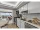 Galley kitchen with stainless appliances, white cabinetry, and a view into the dining and ocean-view living area at 901 S Atlantic Ave # 208, Ormond Beach, FL 32176