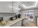 Bright kitchen bar area showcases white cabinets and an opening to a dining/living space with ocean views at 901 S Atlantic Ave # 208, Ormond Beach, FL 32176