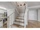 Entry staircase with neutral-colored tiled floors, crisp white risers and railings and adjacent kitchen at 901 S Atlantic Ave # 208, Ormond Beach, FL 32176