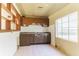 A kitchen featuring a window, a stainless steel sink, and stained wood cabinets and a tiled backsplash at 904 Bordeaux Pl, Orlando, FL 32808