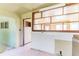 A view from living room into the kitchen with white backsplash tiles and some open shelving above the wall at 904 Bordeaux Pl, Orlando, FL 32808