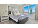 Comfortable bedroom with a gray wood paneled bed frame, light gray comforter, and a bedside table and lamp at 907 Princess Sabal Pt, Haines City, FL 33844