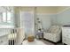 Well-lit baby bedroom featuring a white crib, animal artwork, and a patterned chair at 907 Princess Sabal Pt, Haines City, FL 33844