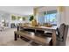Dining area featuring a long wooden table with bench seating, open to the living room with modern decor at 907 Princess Sabal Pt, Haines City, FL 33844