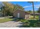 Tan home featuring a simple front door with a cracked concrete driveway and green lawn at 10031 Union Park Dr, Orlando, FL 32817