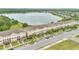 Aerial view of a community of townhomes next to a beautiful lake on a sunny day at 10566 Green Ivy Ln, Orlando, FL 32832