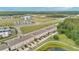 Aerial view of townhomes with pond, trees, and highway in the background at 10566 Green Ivy Ln, Orlando, FL 32832