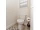 A compact powder room featuring a toilet and a small patterned rug at 10566 Green Ivy Ln, Orlando, FL 32832
