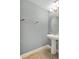 A well-lit bathroom with a pedestal sink and decorative mirror at 10566 Green Ivy Ln, Orlando, FL 32832