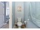 Powder room with light blue walls, decorative painting, and a white toilet at 10566 Green Ivy Ln, Orlando, FL 32832