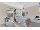 Cozy bedroom featuring a large window, a ceiling fan, a comfortable chair and a well-coordinated decor at 10566 Green Ivy Ln, Orlando, FL 32832