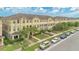 A row of light yellow townhomes featuring well maintained lawns, walkways and private front patios at 10566 Green Ivy Ln, Orlando, FL 32832