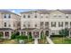 Two-story townhome features an exterior elevation, complemented by meticulously manicured landscaping and walkway at 10566 Green Ivy Ln, Orlando, FL 32832