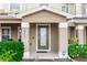 Charming front entrance with a light brown frame door and decorated by two bushes on either side at 10566 Green Ivy Ln, Orlando, FL 32832