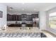 Kitchen island with breakfast bar and dark brown cabinets at 10566 Green Ivy Ln, Orlando, FL 32832