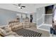 Open living room with ceiling fan, staircase, and an entry view to kitchen, furnished with two sofas and comfy recliners at 10566 Green Ivy Ln, Orlando, FL 32832