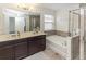 Spacious main bathroom with double sinks, a soaking tub, and a separate glass-enclosed shower at 10566 Green Ivy Ln, Orlando, FL 32832