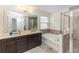 Spa-like bathroom with dual sinks, soaking tub, and glass-enclosed shower at 10566 Green Ivy Ln, Orlando, FL 32832