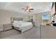 This main bedroom features a tray ceiling, fan, neutral colors, dresser, nightstands and ample natural light at 10566 Green Ivy Ln, Orlando, FL 32832